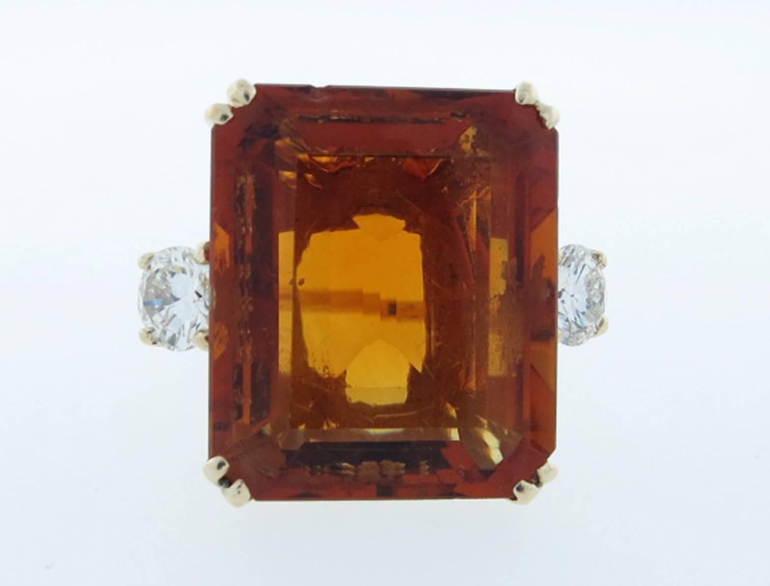 Ladies 14kt. yellow gold ring measuring approx 3/4 inches in length. The center is prong set with a rich caramel color faceted citrine measuring 17.1 x 14.6 x 7.3 mm. weighing approx 11. cts. Each side is set with a very fine diamond each weighing