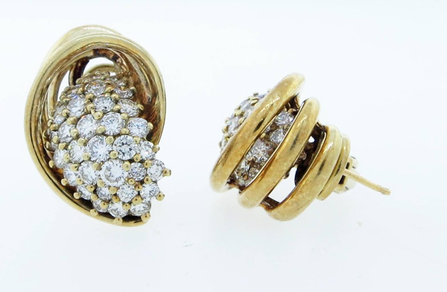 Dimensional design 18kt yellow gold earrings made by Jose' Hess . Each of the 14kt. clip and post back earring is set with 33 round brilliant cut diamonds spilling forth grading Vs clarity H color. Total diamond weigh approx 2.5.0 cts.