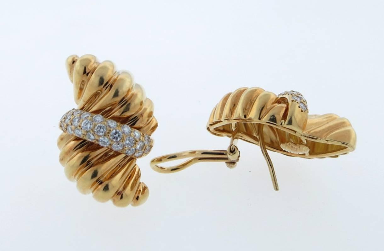 Stylish 18kt. yellow gold fluted rope design opposing design clip and post back earrings. Each earring measures 1.25 inches and is bead set with 25 round brilliant cut diamonds totaling approx .75cts. 