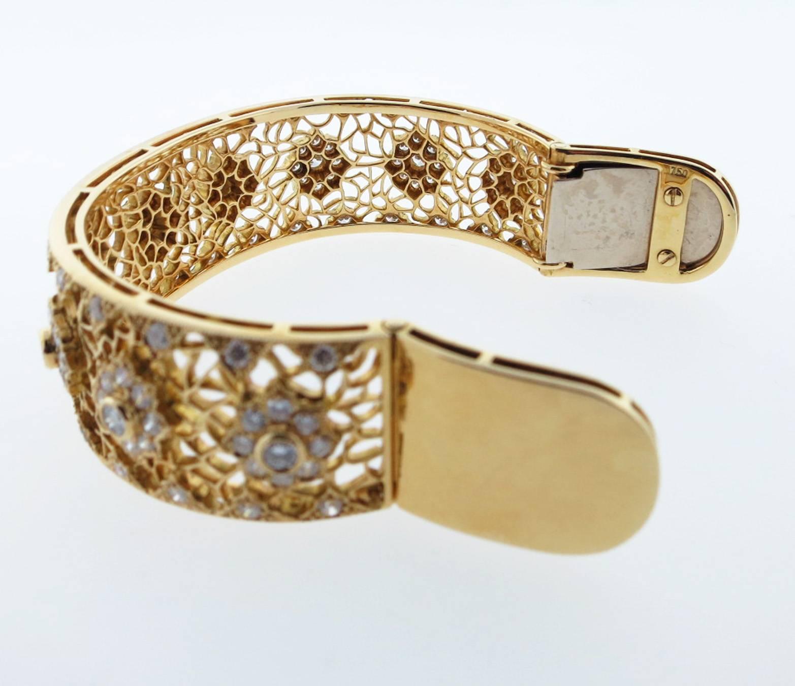 18kt. yellow gold open work floral motif  hinged cuff bracelet. The bracelet is bead and bezel set with 117 round brilliant cut diamonds totaling approx 4.0cts. grading Vs clarity G color. The bracelet will fit most wrists .