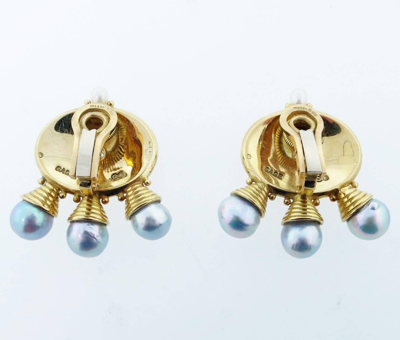 Pair of enamel earrings made by the prestigious  English jeweler Elizabeth Gage. Each 18 kt yellow gold earring is enameled in a rich green and blue enamel with a diamond center and three 8 1/2 mm. pearls. Clip back posts can be added. Signed and