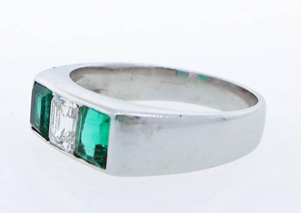 Handmade platinum mount diamond and emerald three stone ring. The center is channel set with an emerald cut diamond weighing approx .40cts. grading VS clarity F-G color. Each side is channel set with a pair of perfectly matched natural extraordinary