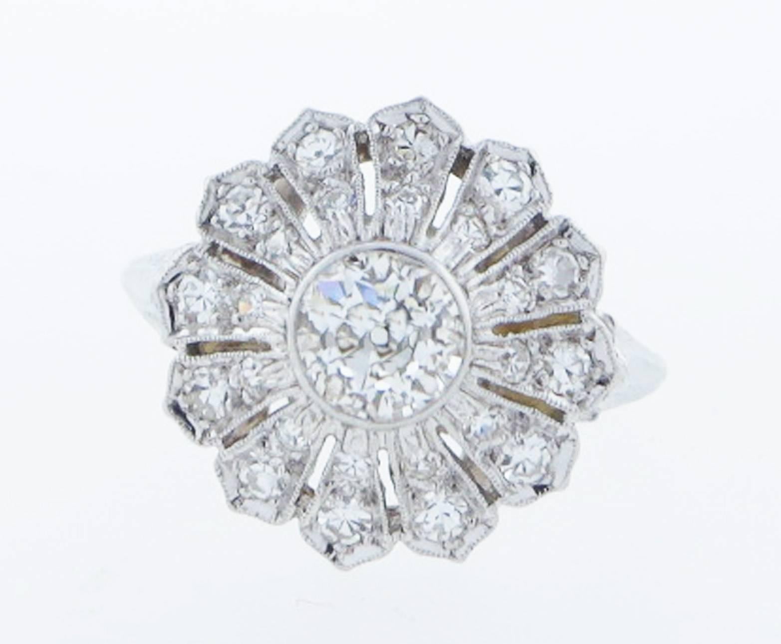 Handmade platinum mount diamond ring in a flower design. The center is bezel set with a round European cut diamond weighing approx .70cts. The surrounding mount is bead set with 24 old cut diamonds totaling approx 30cts.
The ring is size 7 3/4 and
