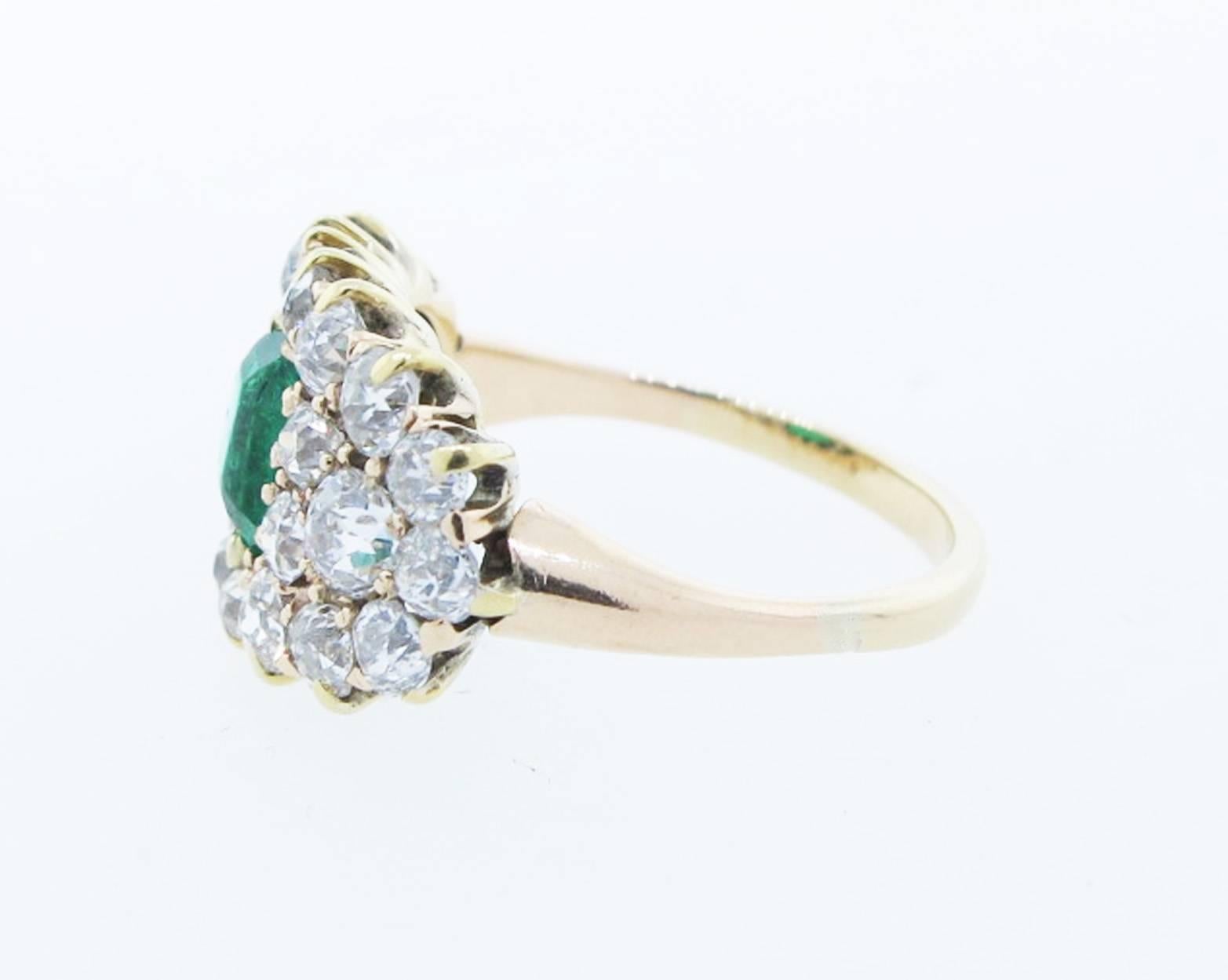 Handmade 14kt. yellow gold band style ring circa 1900. The center is set with an emerald cut faceted natural emerald of beautiful color weighing 1.0cts. The wrap around mount is prong set with 24 old mine cut diamonds totaling approx 1.2cts. grading