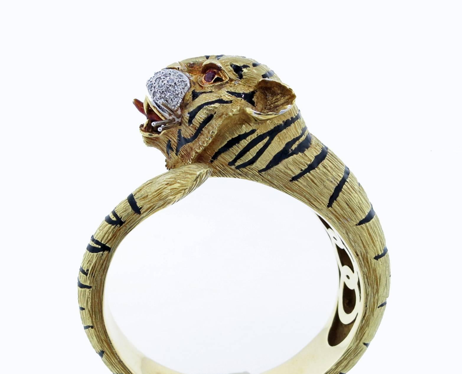 Impressive textured well executed 18kt yellow gold hinged tiger bracelet. The tiger stripes are in black enamel, the whiskers and face are white gold. The face is bead set with 44 round brilliant cut diamonds. The eyes are set with round faceted