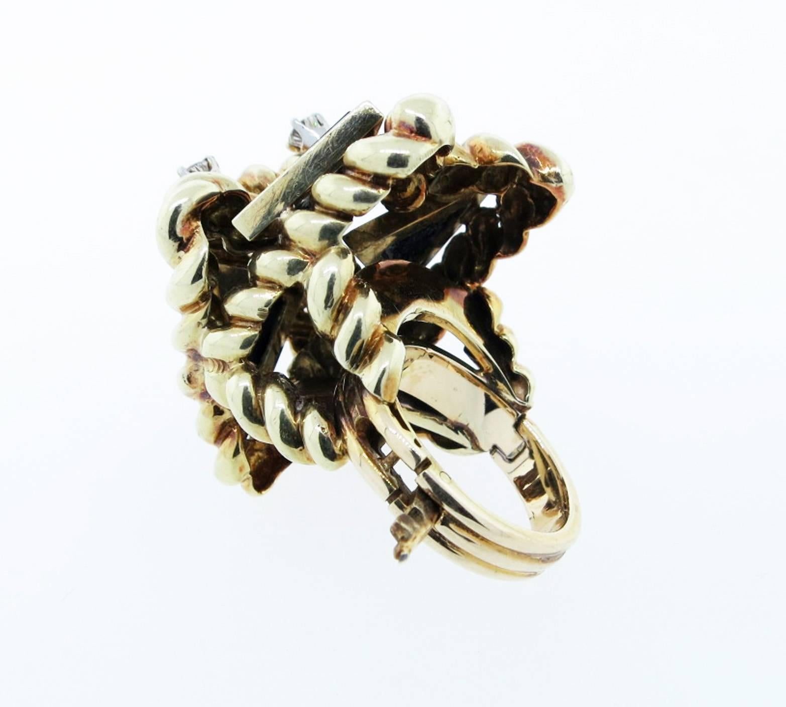 Over sized dimensional 18kt. yellow gold rope design ring measuring over 1 1/4  inches in length in a modernist design.
The ring is set with three bezel set triangles of black onyx and prong set with three round brilliant cut diamonds each weighing
