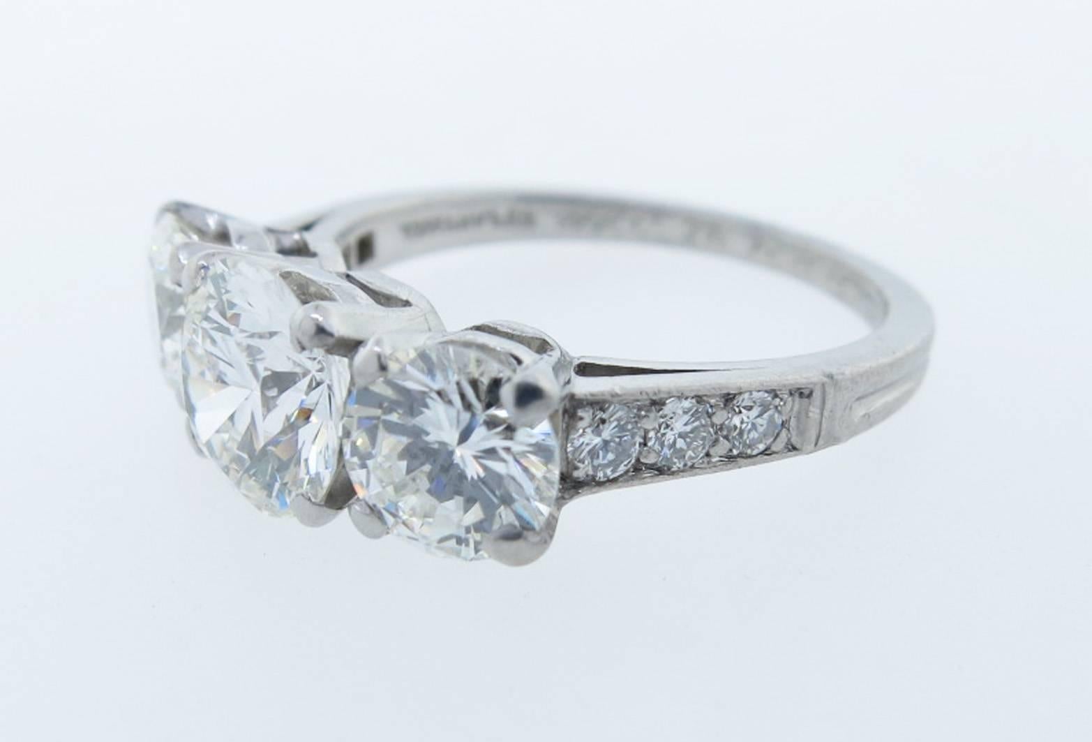 An everlasting classic Tiffany & Co. diamond ring in platinum. The center is prong set with a round brilliant GIA report diamond weighing 1.1cts. grading VVS1 I color. Each side is set with a round brilliant cut diamond weighing approx .55cts.
