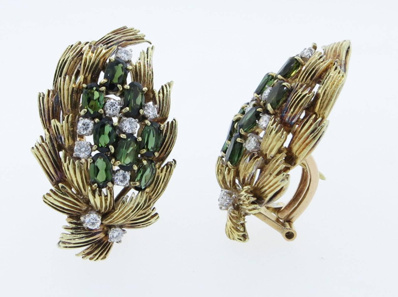Opposing 18kt. yellow gold wheat design clip and post back earrings. Each earring is prong set with eight oval faceted natural green tourmaline sprinkled with nine round brilliant cut diamonds totaling .65 cts. The earrings measure approx 1.3 inches
