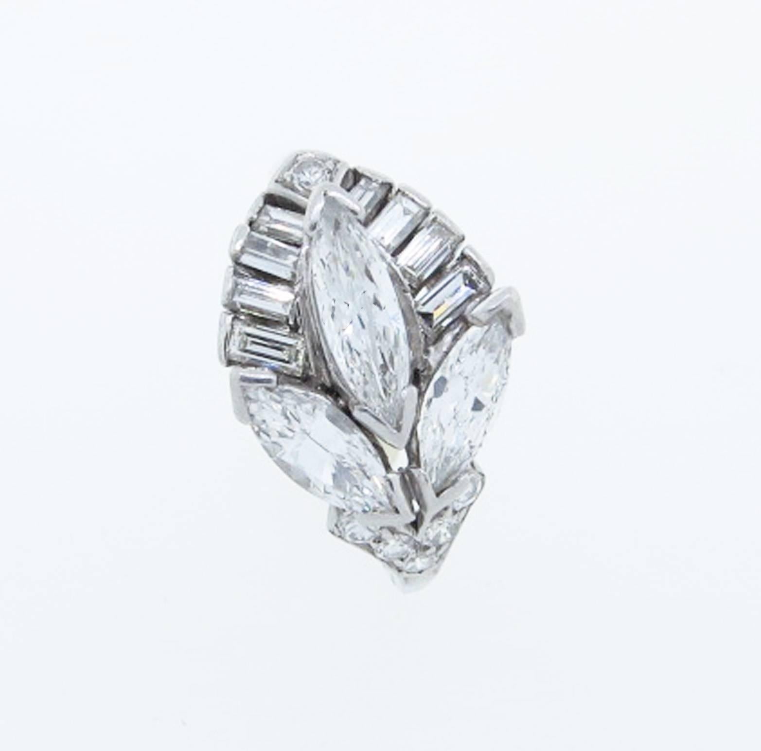 Powerful leaf design platinum mount ring circa 1950. The ring is set with a center marquise cut diamond weighing approx .50 cts., two side marquise cuts,  8 baguettes and 6 round cut diamonds totaling an additional 1.05cts. The diamonds grade Vs