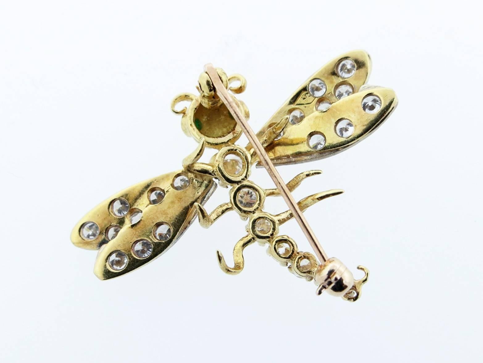 18kt. two color diamond dragonfly brooch.The wings and body are bead with  25 round brilliant cut diamonds totaling approx 1.0cts. grading VS clarity F-G color. Natural faceted emerald eyes.