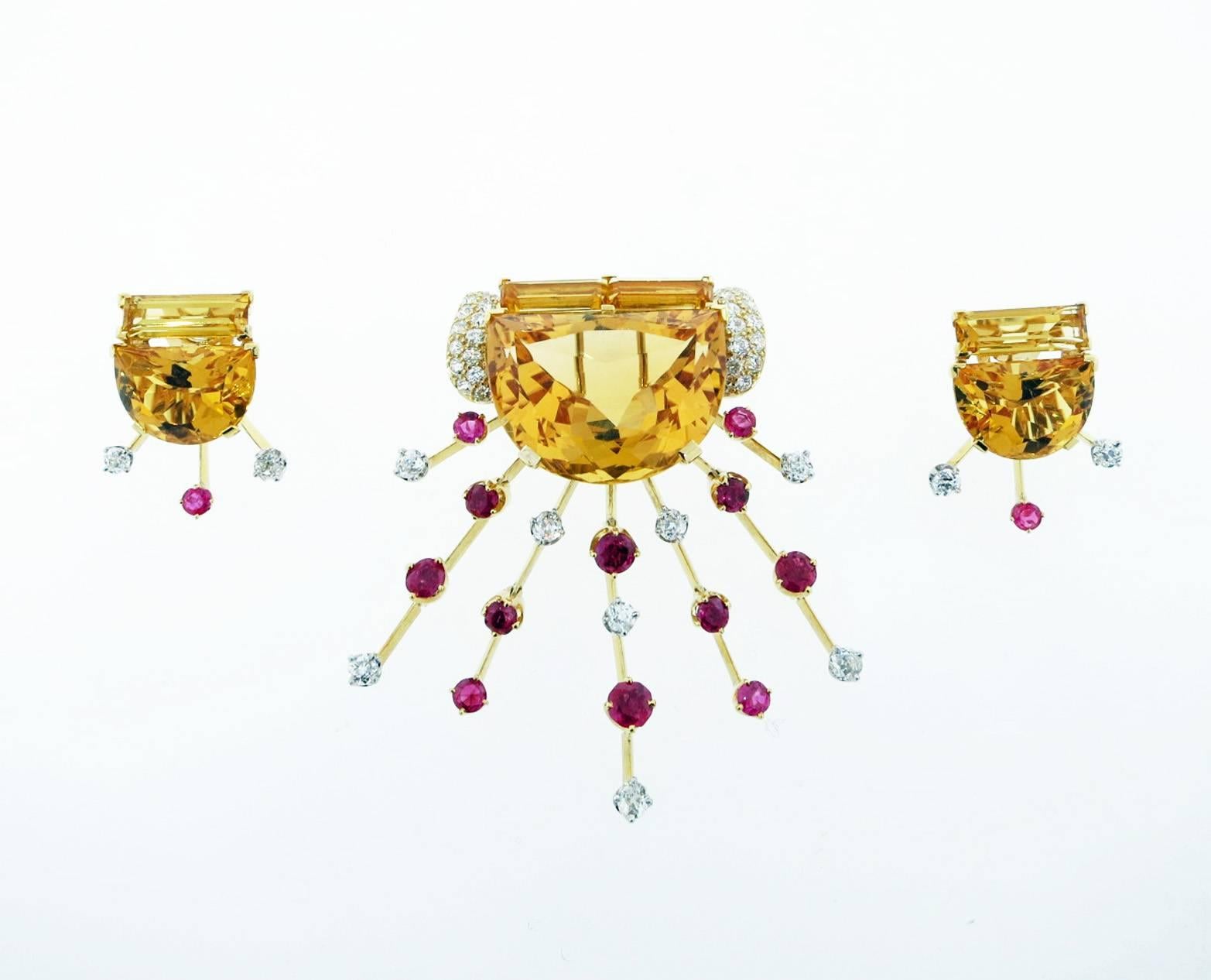 18kt. yellow gold brooch the center is set with a moon shape citrine weighing approx 70cts. topped with two baguette cut citrines flanked with half moons of pave set diamonds. Radiating down with articulated rays of round natural faceted rubies and