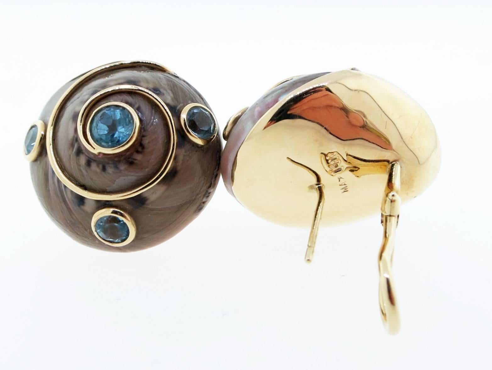 Natural sea shell earrings each bezel set with four faceted round blue topaz mounted in 14kt yellow gold with clip and post backs. Light weight and very comfortable to wear. Signed .