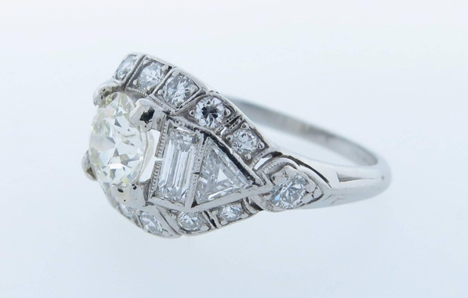 Handmade platinum mount Art Deco diamond ring with fancy cut diamond mount. The center is prong set with a round European cut diamond weighing approx .73cts. grading VS clarity J color. Each side is set with a triangular and baguette cut diamond.