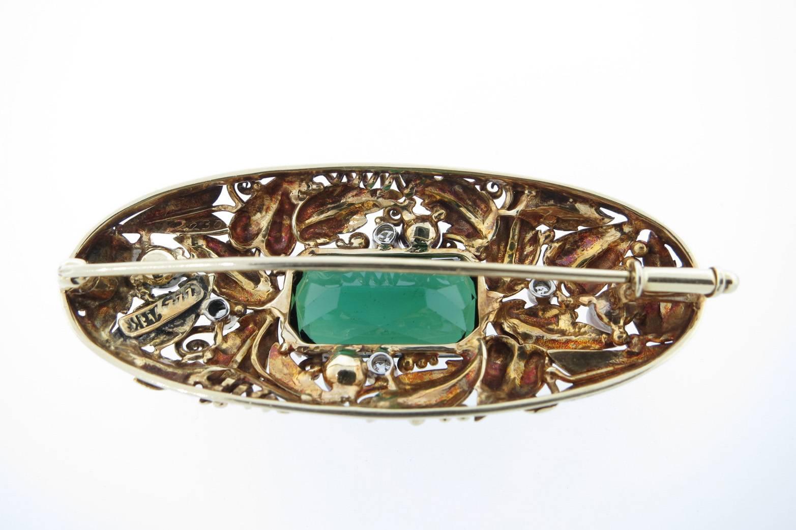 Exceptional condition brooch dating from the Arts and Crafts period circa  1900 measuring 2 inches in length.The center is prong set with a faceted natural green tourmaline weighing approx 3.75 cts. The organic foliate design frame is mill-grained