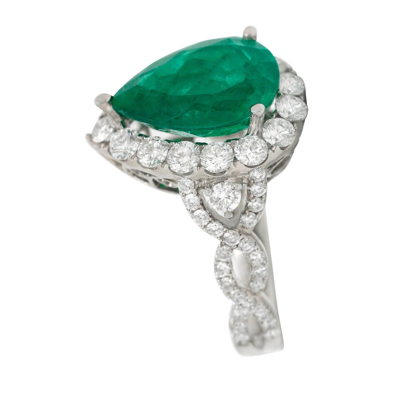 Ring is made of 18kt white gold and set with 1.76ct of natural round brilliant cut diamonds VS clarity and F-G color.  The Emerald is pear shape, weighs 4.55ct and is a beautiful color vitually free from eye visible inclusions.