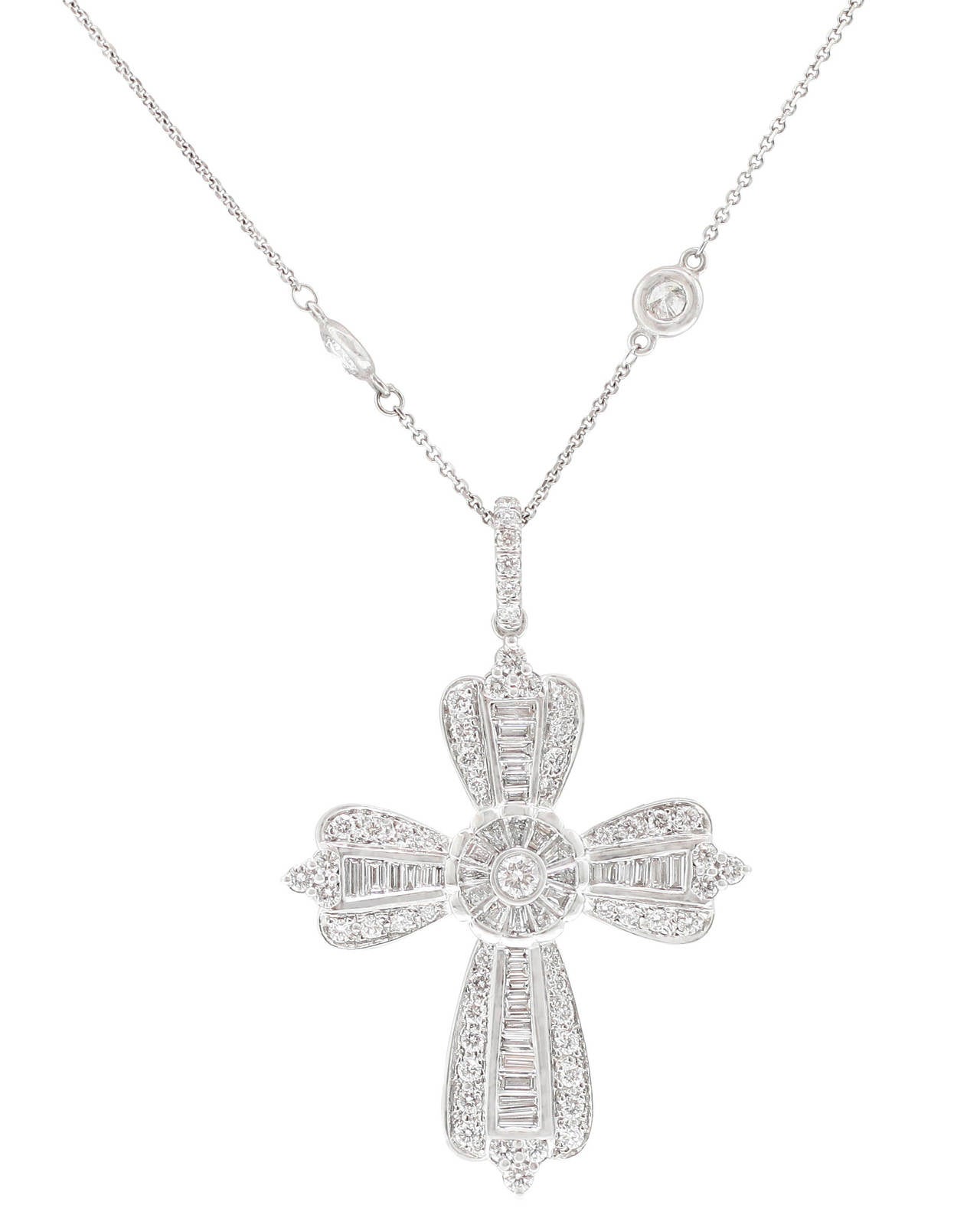 This most incredible Custom Diamond Cross Pendant features a center of tapered baguette diamonds in bezel settings with bead-set round brilliant-cut diamonds outlining the bezels, and creating a fluted edge. A larger round diamond anchors the center