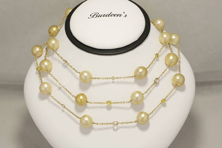 Yellow pearl necklace featuring 23 natural cultured pearls 11-12 mm in diameter.  The 18kt yellow gold bezels hold an assortment of diamonds both white and fancy intense yellow, with cuts including, rose, round brilliant, heart, princess, and pear. 