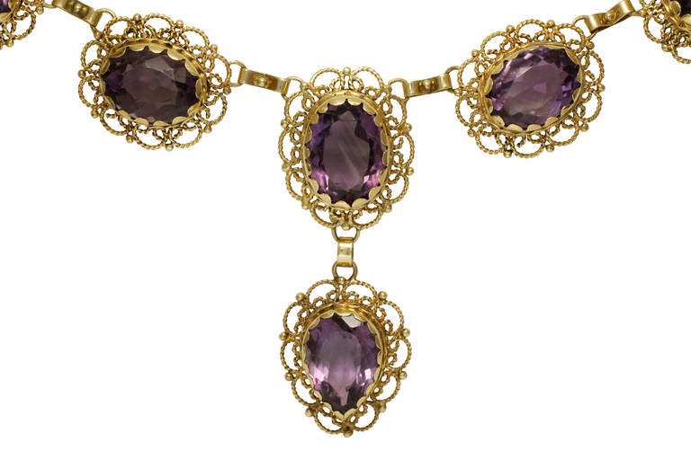 This very ornate and true vintage piece is made of 14 kt yellow gold and contains 14 natural amethyst of various size.