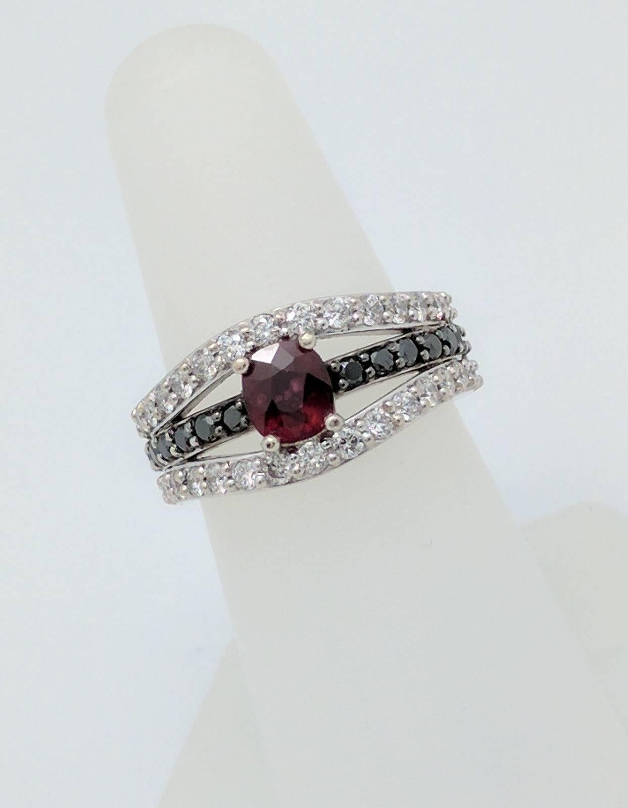 You are viewing a beautiful custom made ruby, black and white diamond ring. Any woman would love to add this piece to their collection!

This ring is crafted from 14k white gold and weighs 10 grams.  It features (1) .50ct natural black box ruby,