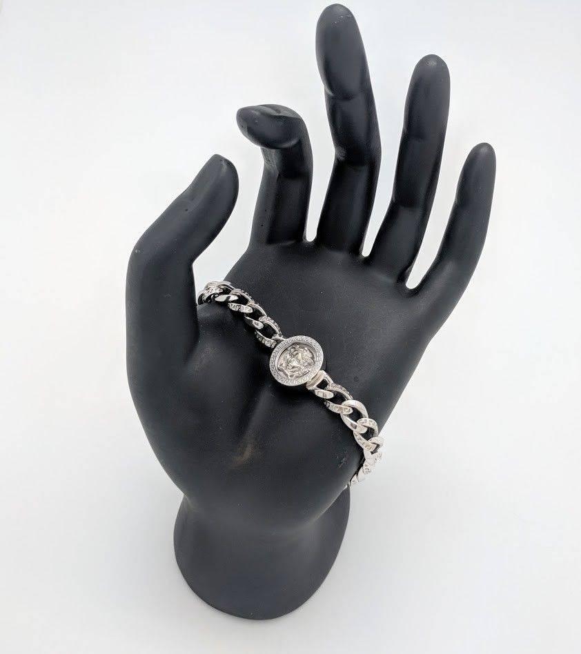 You are viewing a Unique Gianni Versace Kette Medusa Curb Link Bracelet that is sure to make a statement!
This bracelet is crafted from 18k white gold, measures 6.8mm in width and weighs 34 grams. It features one 14.7mm Medusa charm and offers a