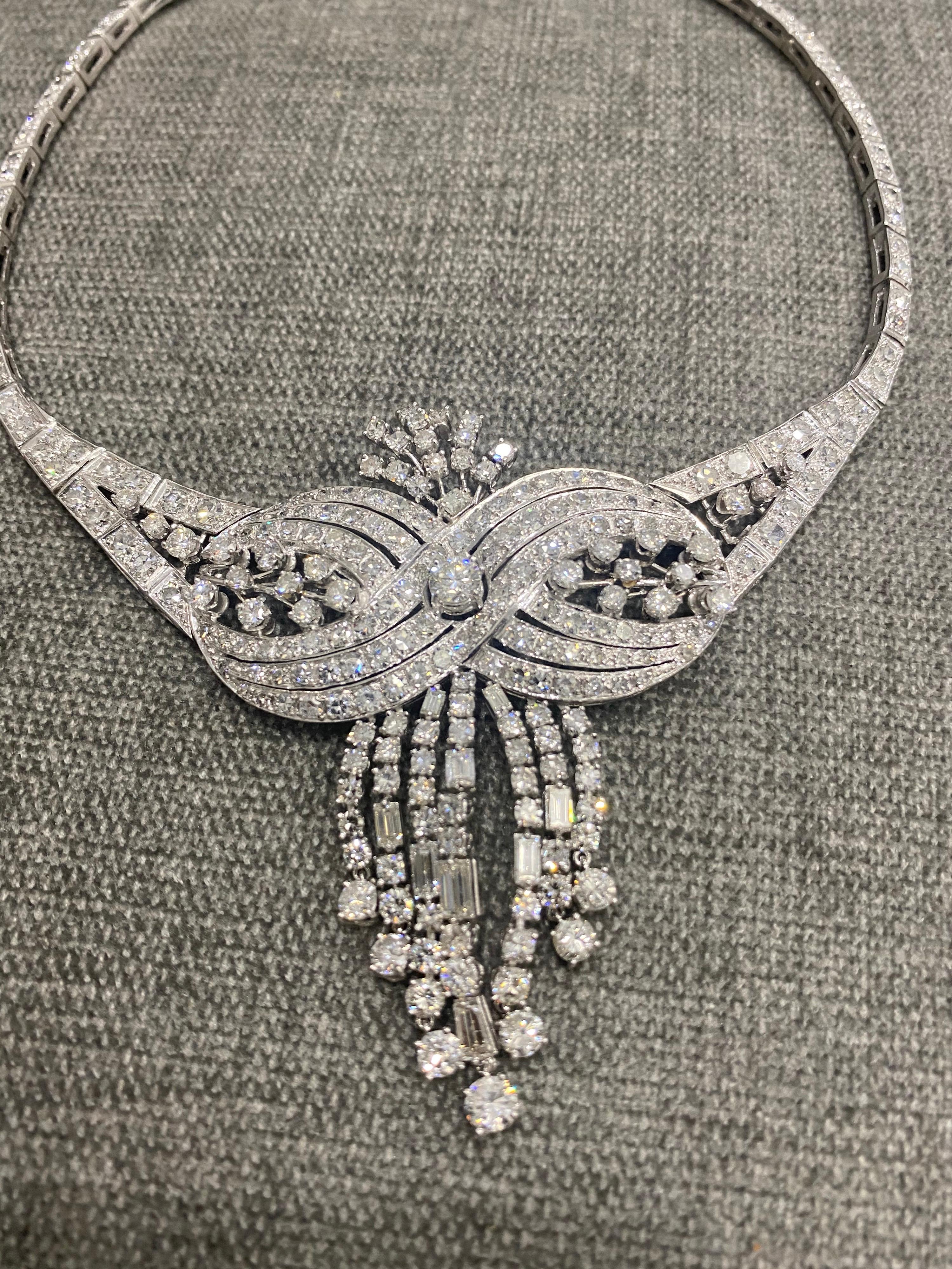A look that is truly spectacular — this original Circa 1950's vintage platinum and diamond necklace includes approximately 19.20+ carats total weight in brilliant round- and single-cut diamonds, with larger baguette-cuts dripping down the front, for