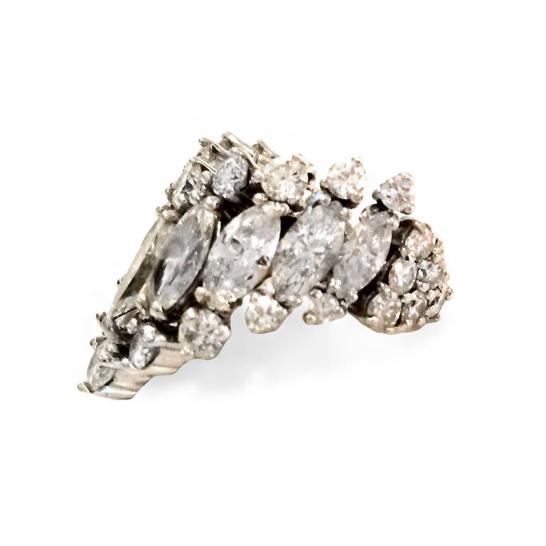 Platinum 1950s ring highlights 9 marquise-cut diamonds (approx. 5.50 ct total weight) framed with 34 round-cut diamonds (approx. 2.50 ct total weight). Handmade setting features asymmetric, graduating design.