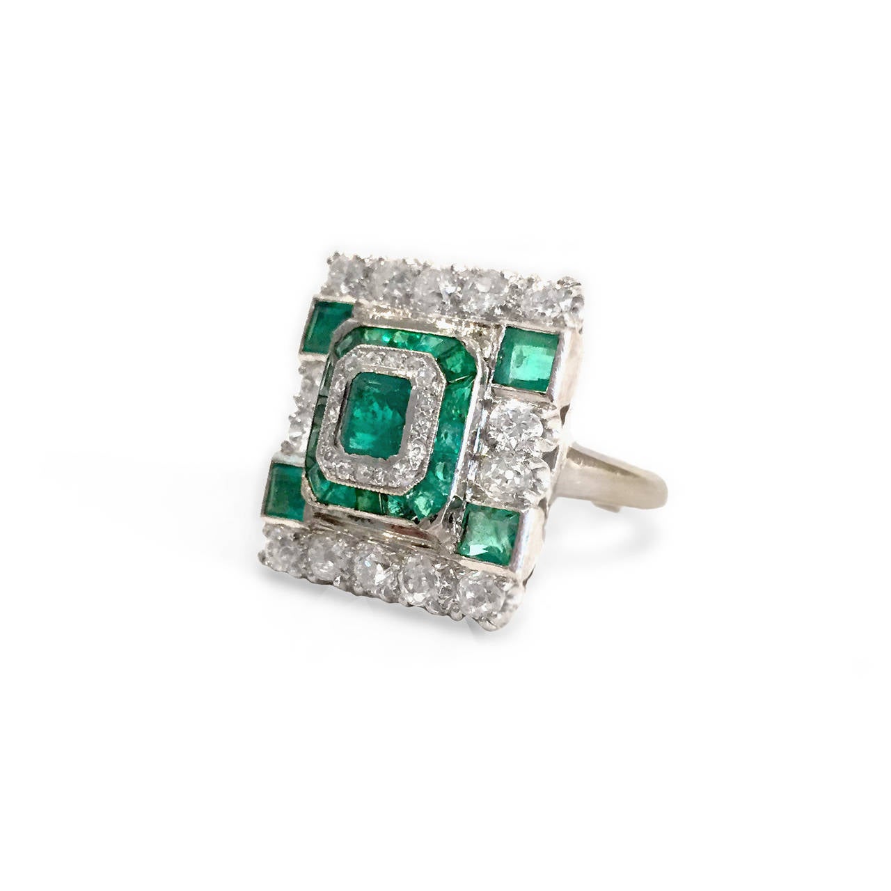 With its true-to-Art-Deco lines, this ring is a real eye-catcher. 14k white gold setting surrounds approximately 2 carats in round-cut diamonds and 1.25 carats of princess-cut emeralds, in a classic geometric configuration. 5/8 inch long. Currently