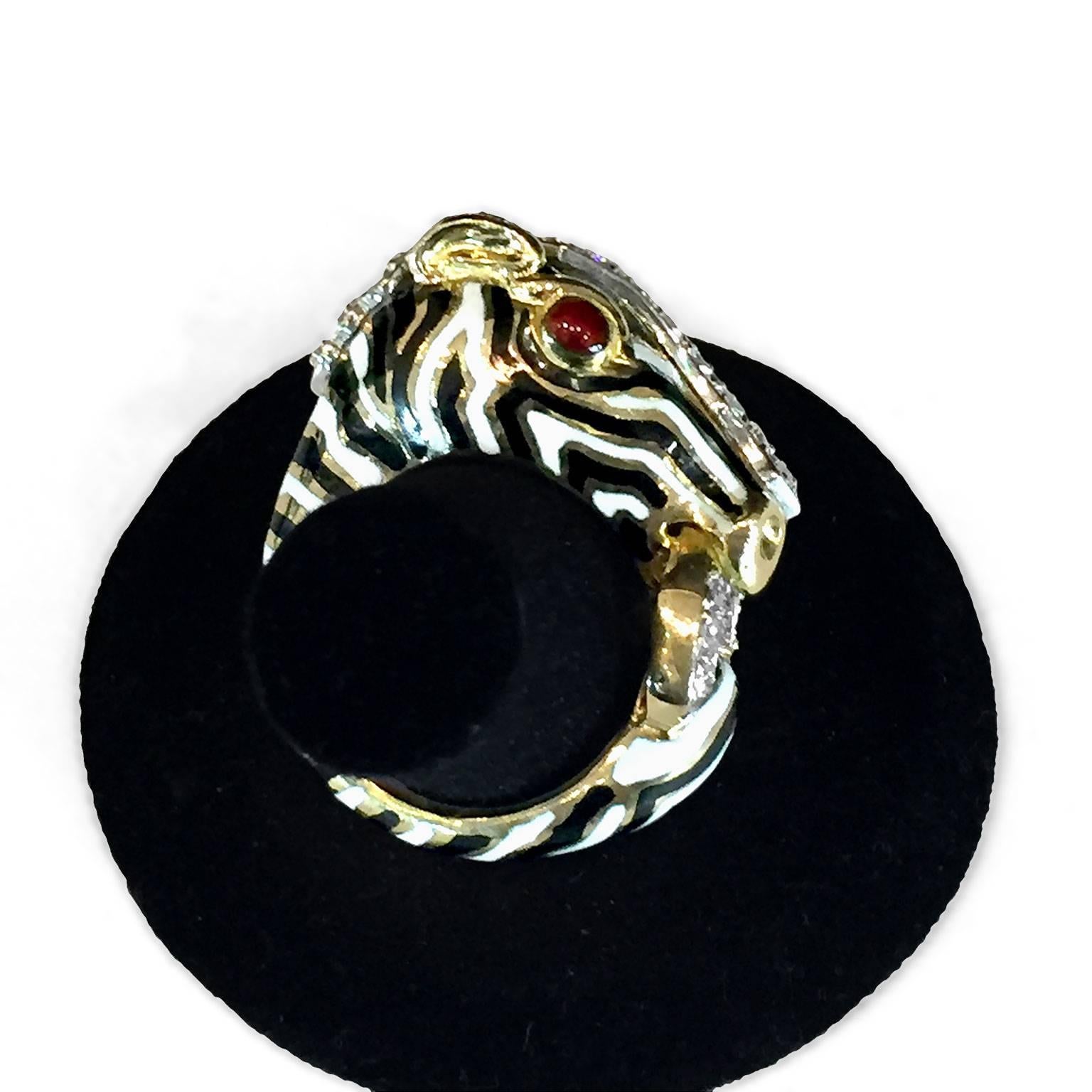 From renowned jewelry designer David Webb comes this striking 18k yellow gold diamond and ruby fashion ring. White and black enamel stripes alternate along the band and across the zebra face, adorned with ruby eyes. We're proud to have this