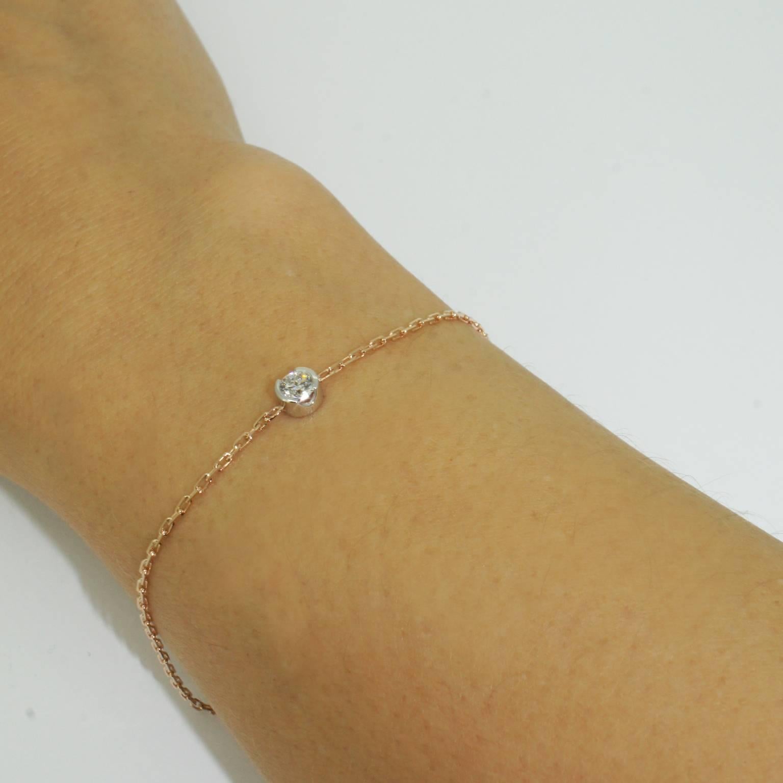 A timeless, simple design, this feminine bracelet features a sparkling round brilliant cut diamond in an 18 karat white gold setting, on an 18 karat rose gold chain. The diamond's setting is open on the sides allowing plenty of light in and adding