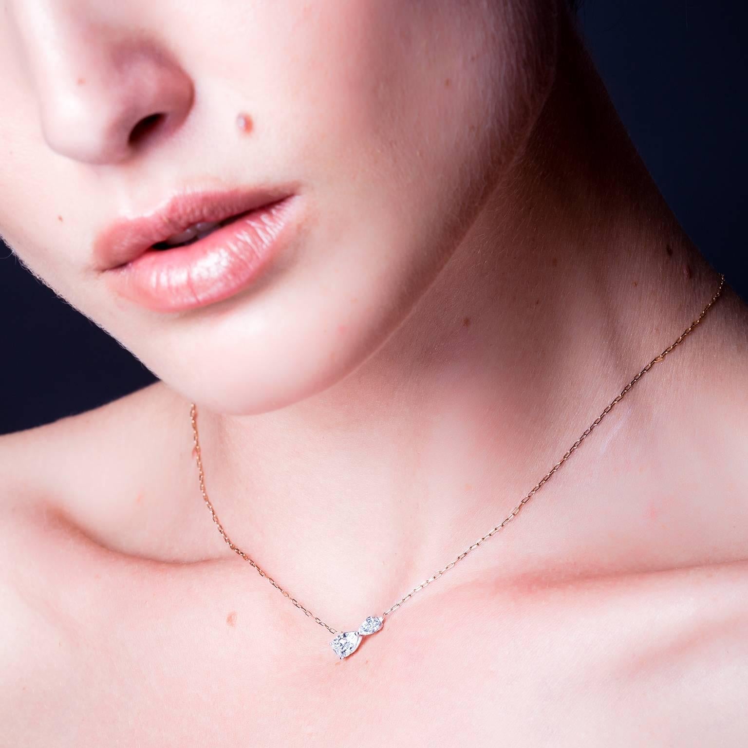 Inspired by the sign of infinity and the graceful lines of pear cut diamonds, this beautiful, feminine diamond necklace is handmade in 18 karat white gold. Suspended on a fine, sparkling 18 karat rose gold chain, it creates an impression of the