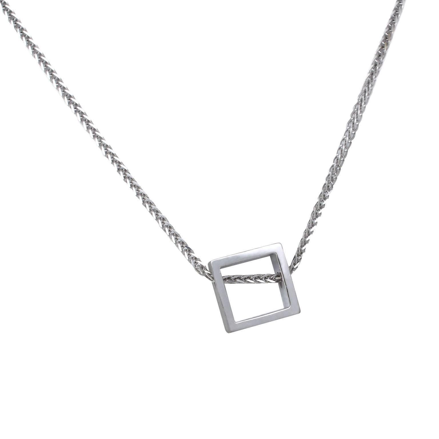 This minimalist geometric pendant sits slightly off-centre, creating a playful effect, and expressing the idea of non-conformity within the boundaries of conformity. The pendant's design utilises negative space, transforming it into a miniature