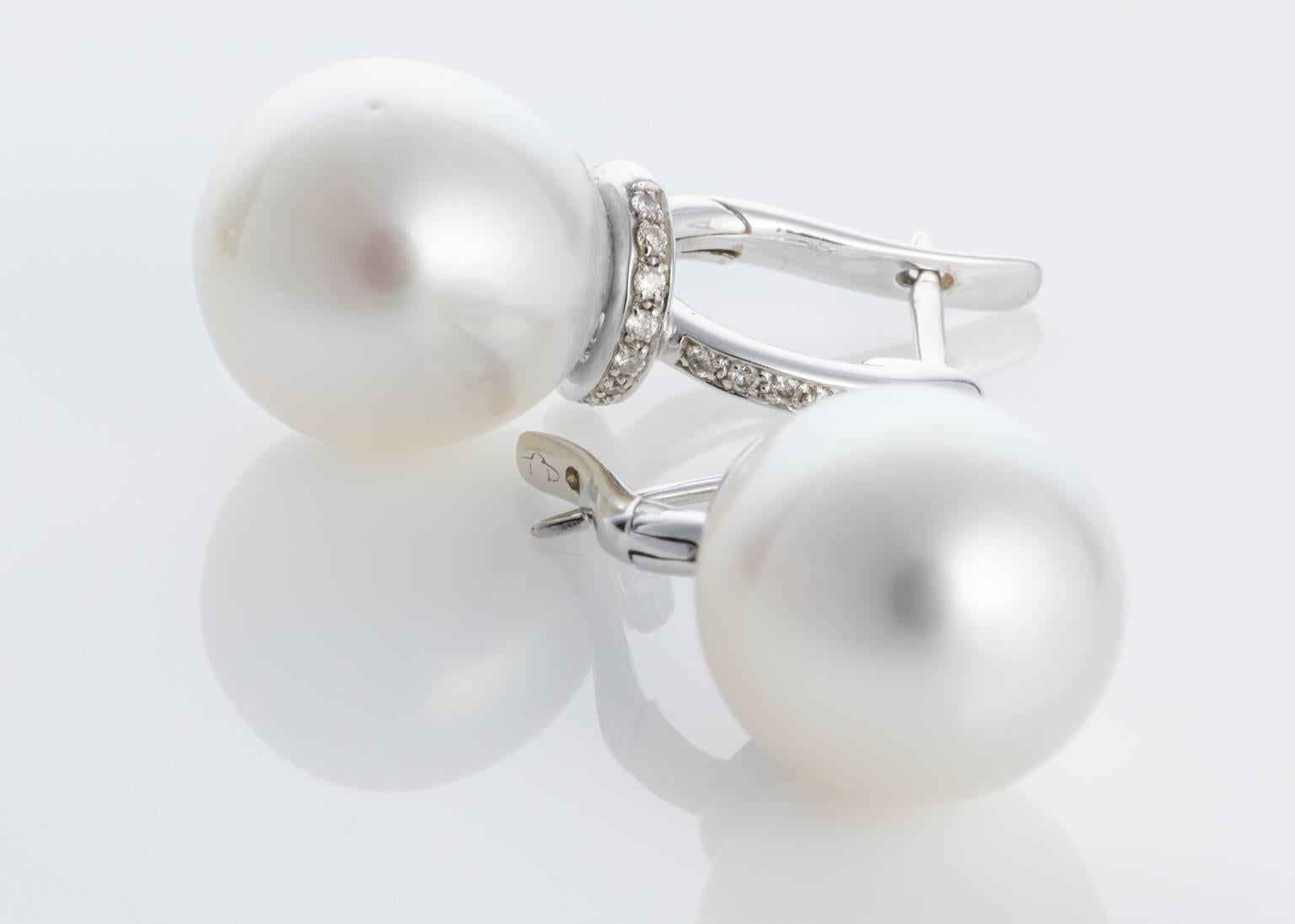 A magnificent pair of South Sea Pearl & Diamond earrings. Set with two South Sea pearls from Broome, Australia, weighing 12.5-13mm, oval shape, silver white in colour, very good lustre, A-1 quality. Set with approximately 0.20cts of brilliant cut