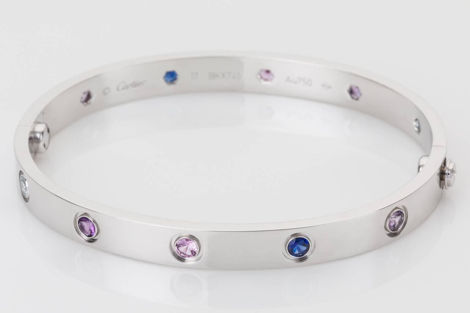 Contemporary, elegant & collectable this 18k white gold Cartier love bangle is set with a total of ten gorgeous gemstones,  two aquamarines, two pink sapphires, two blue sapphires, two purple spinels and two amethysts and comes complete with the