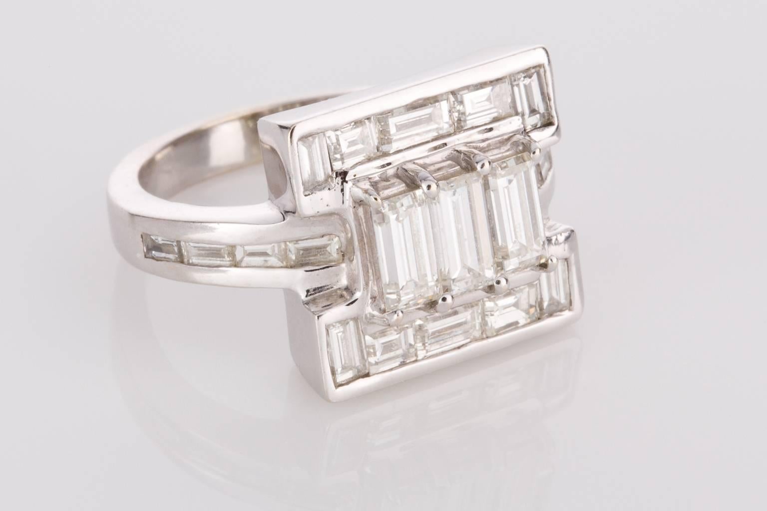 A gorgeous 18k white gold ring containing three raised claw set central baguette cut diamonds framed by five channel set baguette diamonds either side. Mounted onto a 3.20mm wide band with four channel set diamonds at the side. Total Diamond weight