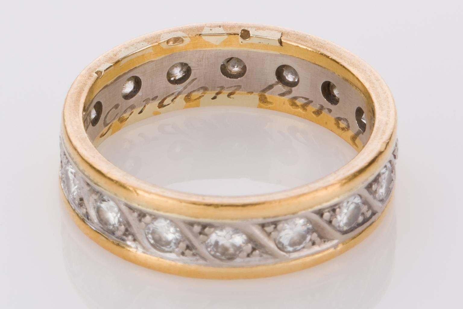 A lovely old two tone 18k white and yellow gold never-ending band set with 16 round brilliant cut diamonds weighing approximately 0.80cts. The diamond set centre of the ring is 18k white gold with a swirl pattern between each diamond with outer