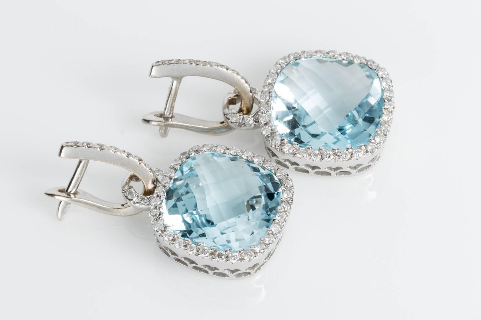 Fabulous for day or night, these pretty blue topaz earrings will suit all occasions. One pair of 18k white gold finely designed and crafted Blue Topaz and diamond drop halo style cluster earrings. The main cluster setting is fully removable with