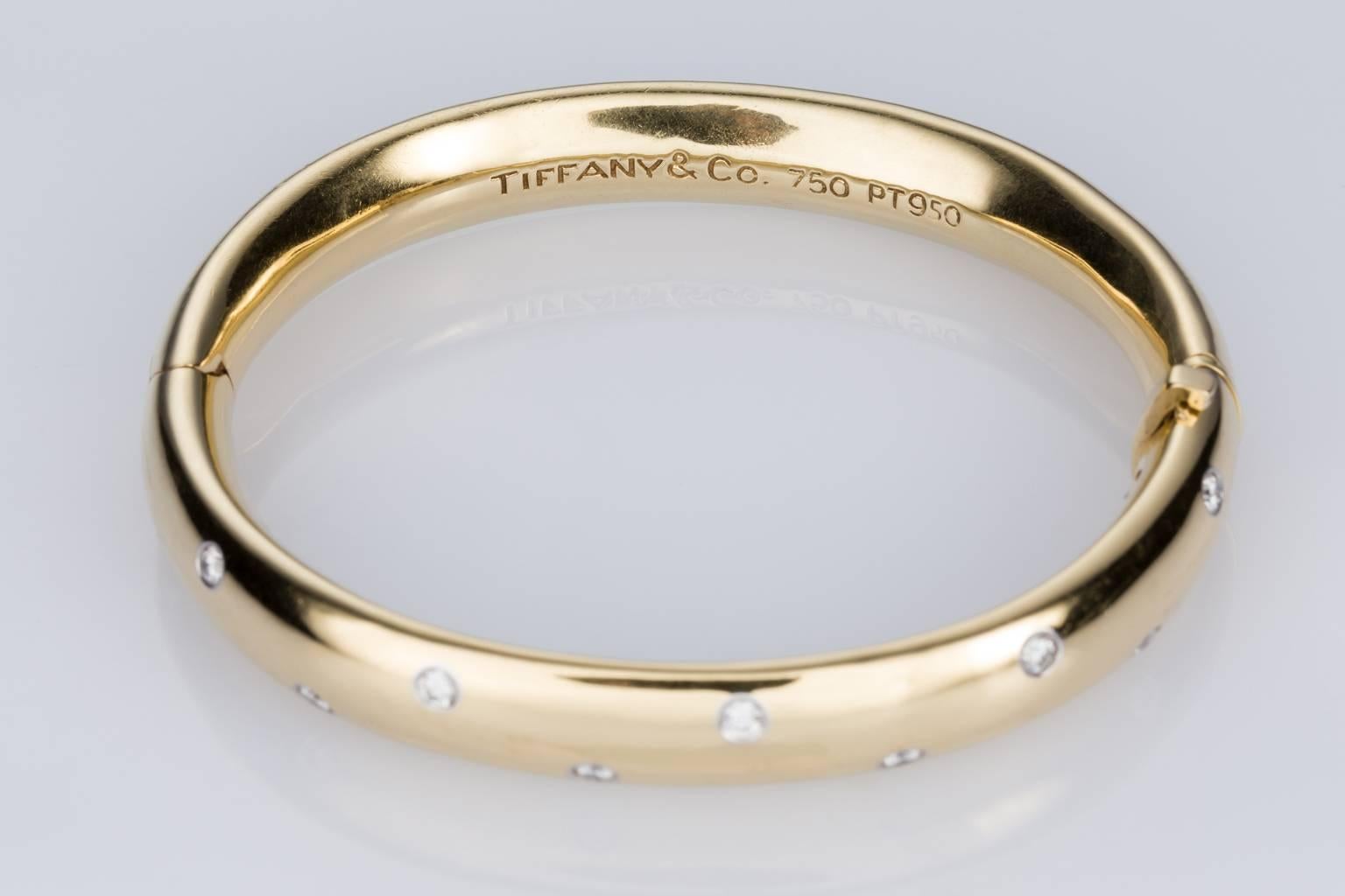 A fabulous Tiffany & Co yellow gold and platinum Etoile Bangle. A great look on the arm with 10 brilliant cut white diamonds weighing approximately 0.60cts with each diamond set in a fine platinum surround. 18k yellow gold with a weight of 