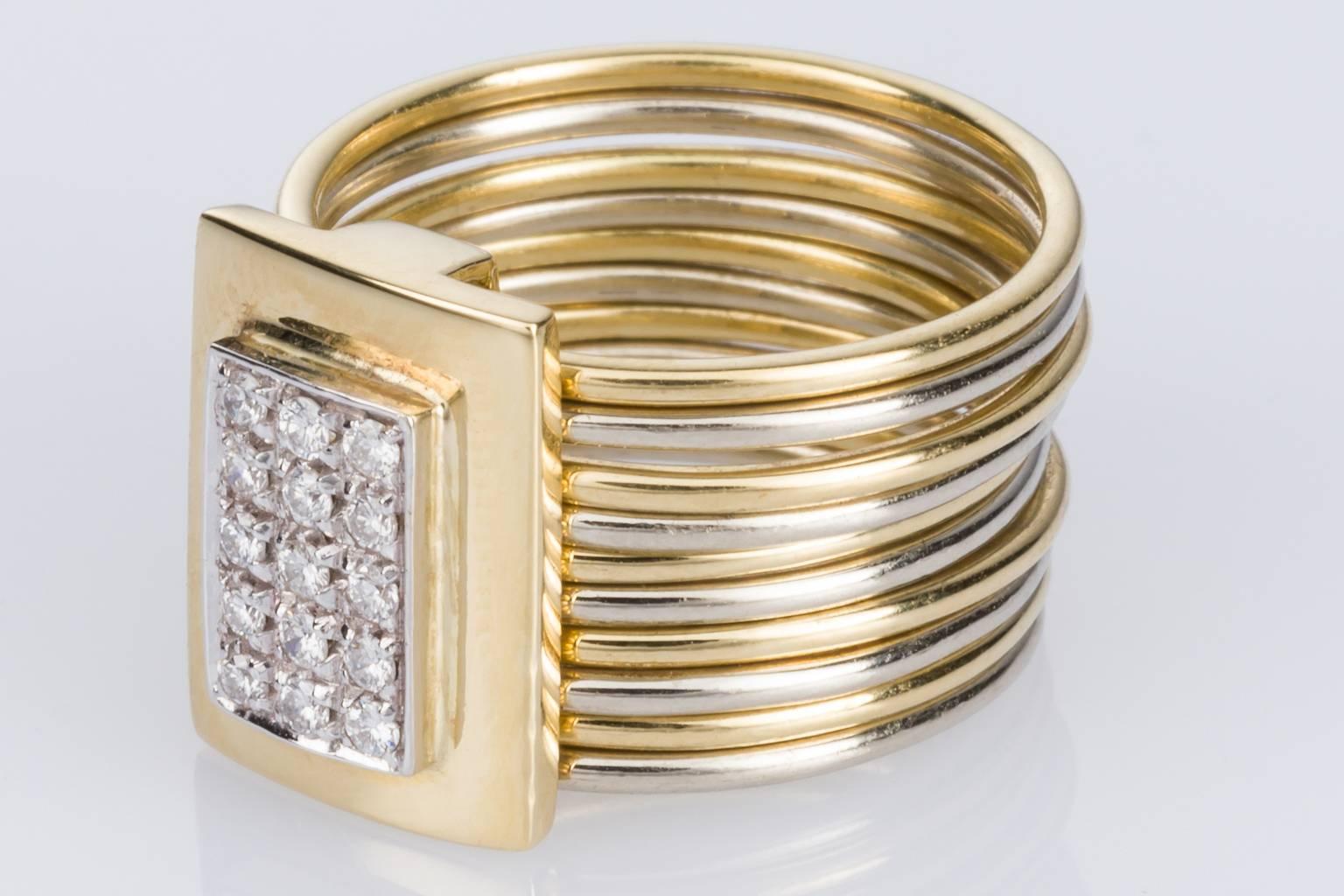 A stunning Damiani Multi Band ring consisting of 10 individual rounded bands alternating between white & yellow gold and each one measuring 1.00 x 1.00mm, with an attached sliding rectangular feature piece set with 15 grain set diamonds. The modern