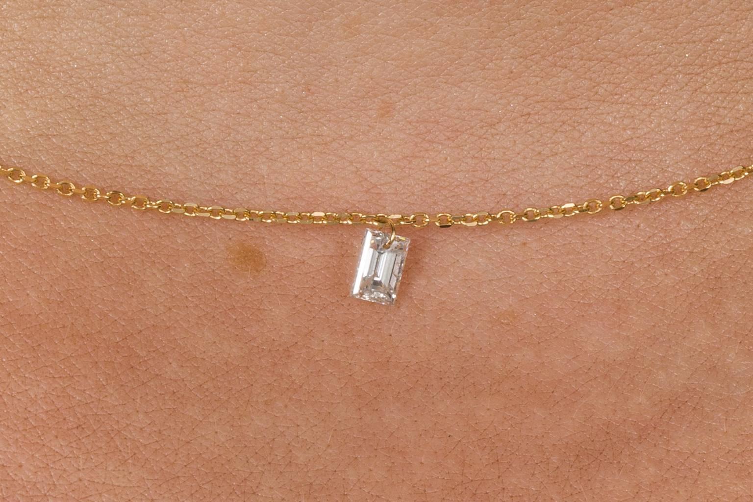 This pretty necklace has the most delicate look to it. A beautiful 18k yellow gold very fine trace link chain with a baguette cut diamond weighing 0.195cts hangs from a small gold jump ring. A hint of sparkle can been seen with the movement of your