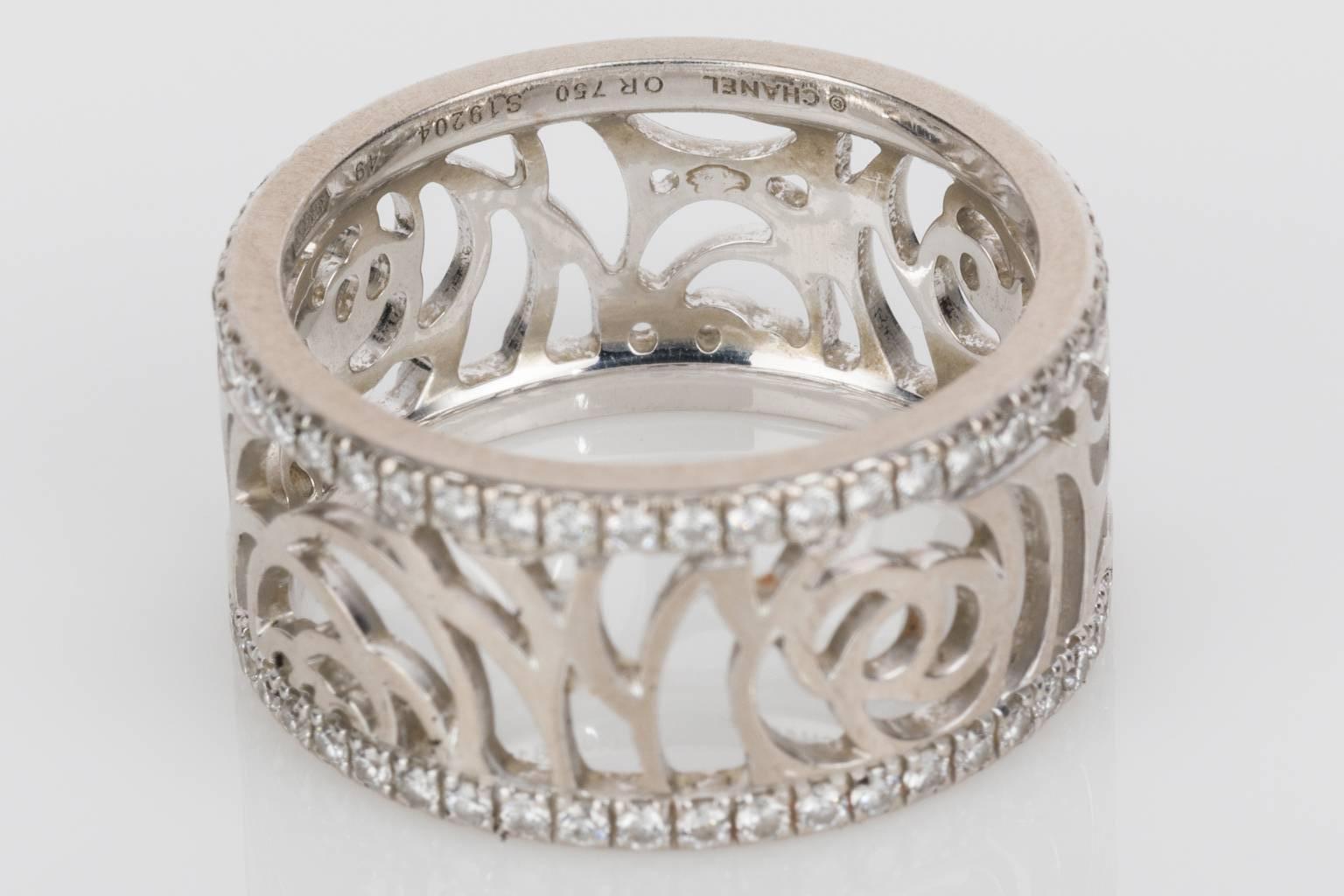 A very pretty 18k white gold Chanel Ajoure Diamond band ring, circa 2012. Set with approximately 0.40cts of brilliant cut white diamonds along the two edges of the ring with the pierced band replicating the camelia motif between the two diamond
