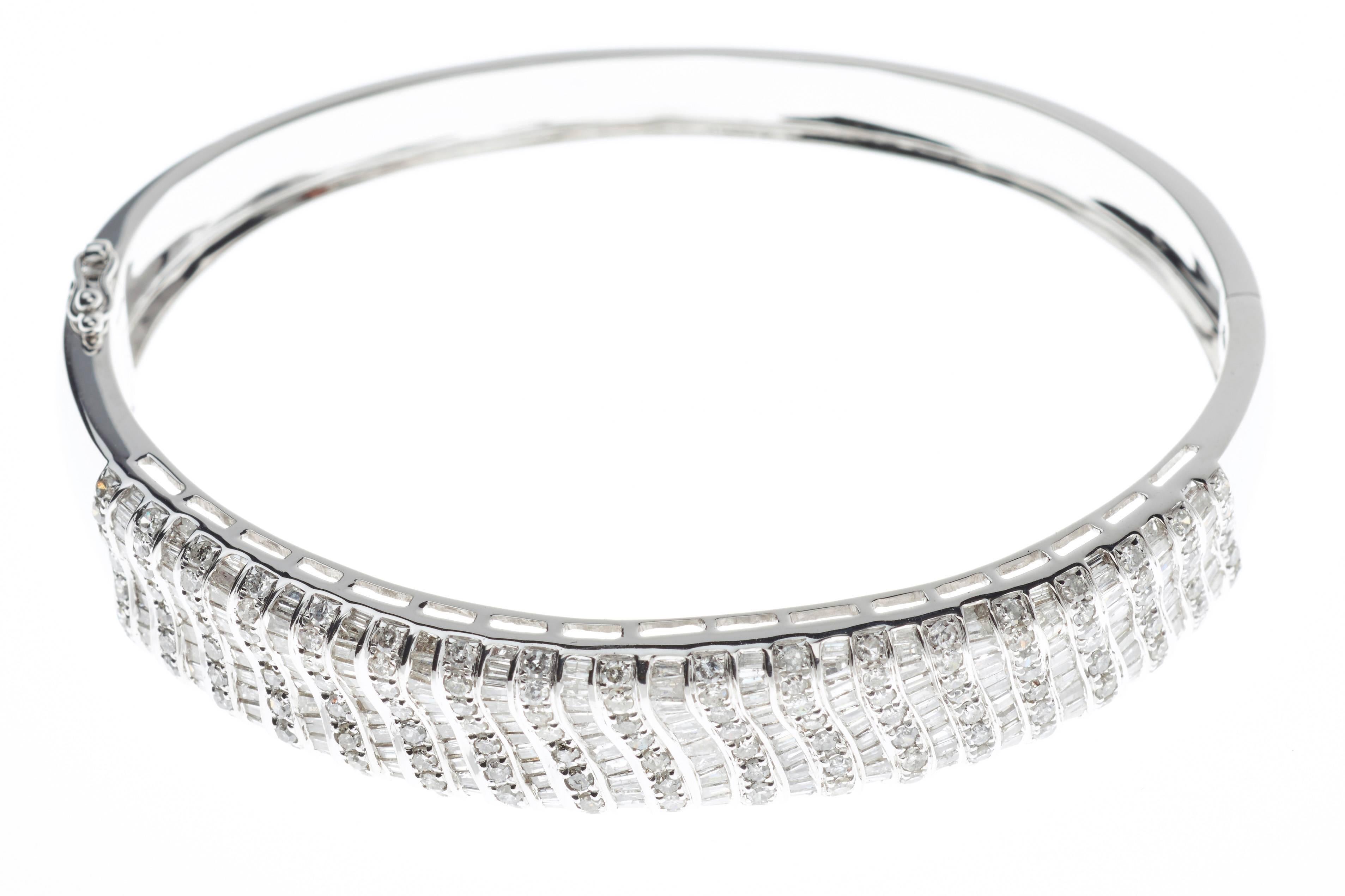 A fancy diamond bangle; featuring a combination of 142 round brilliant cut diamonds (total 1.74 ct) and 208 tapered diamonds (total 2.64 ct) set in 18 carat white gold (total 26.21 grams) 

350 Total Diamonds 4.38ct
18ct White Gold
Free Express