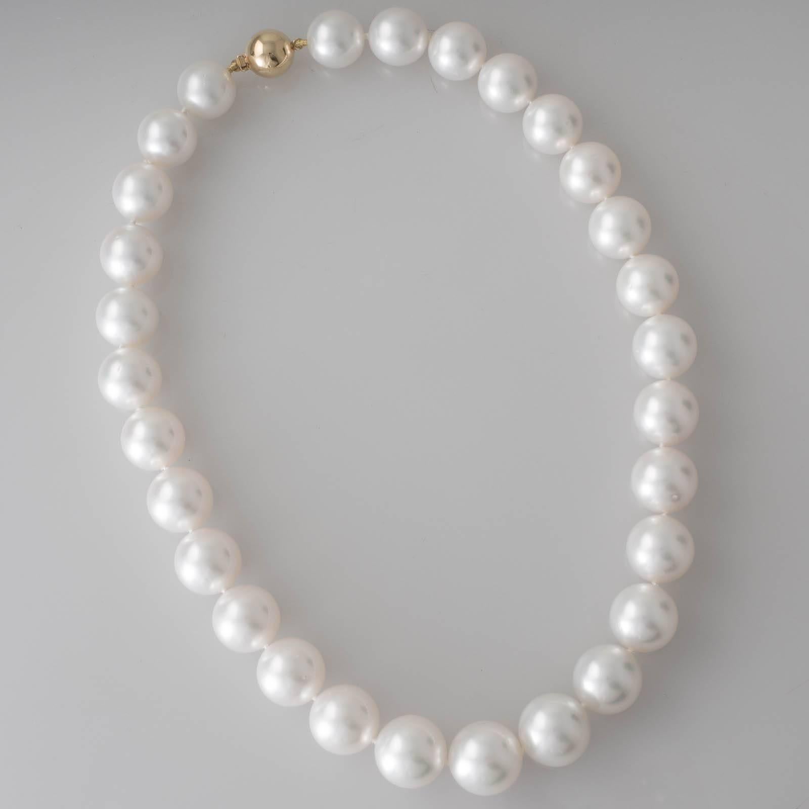 A strand of round white South Sea pearls measuring 14 - 16.8mm with a magnificent lustre and almost no natural surface marks. 29 pearls threaded to a polished 18ct yellow gold ball clasp.