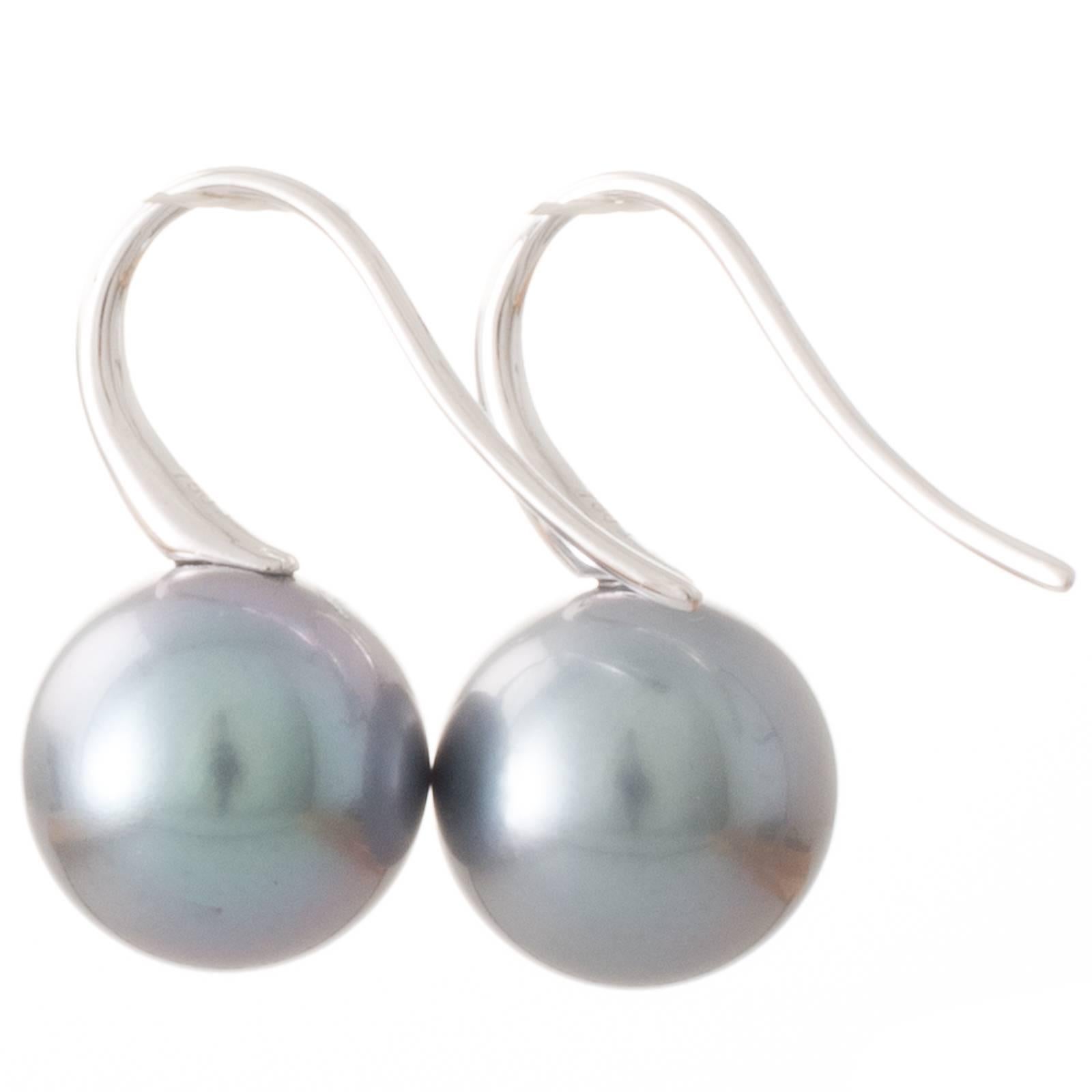 A pair of 18ct white gold Tahitian South Sea pearl earrings set with two round grey aubergine Tahitian pearls measuring 10 - 11mm with a good lustre and few natural surface marks. Set with 18ct white gold short hooks. 