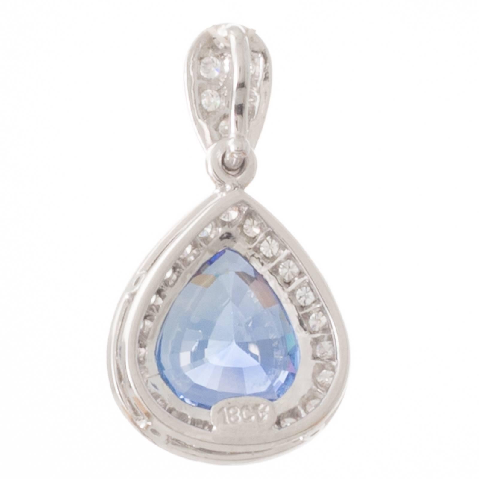 An 18ct white gold pendant with a GIA certified 3.54ct pear shaped Sri Lankan sapphire surrounded by a border of twenty two grain set brilliant cut diamonds with a millegrain edge below an articulated diamond set bail. 
Total Sapphire Weight: 3.54ct
