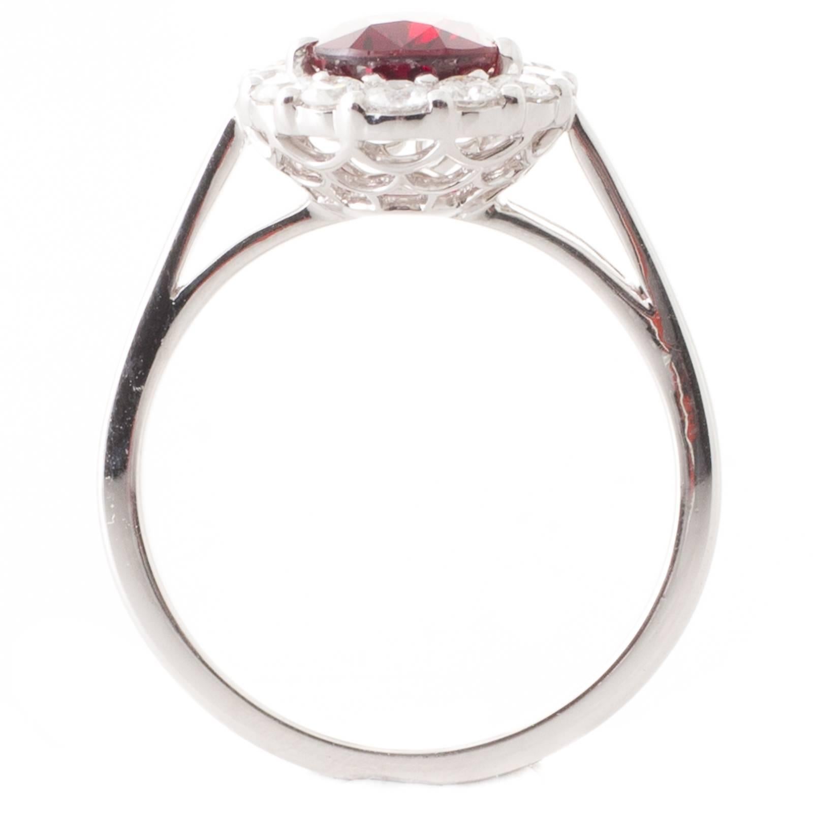 18ct white gold ring claw set to the centre with a 1.57ct GRS certified Mozambique ruby with a surround of fourteen claw set round brilliant cut diamonds all above a filigree style undergallery to upswept shoulders and a plain polished band. Total