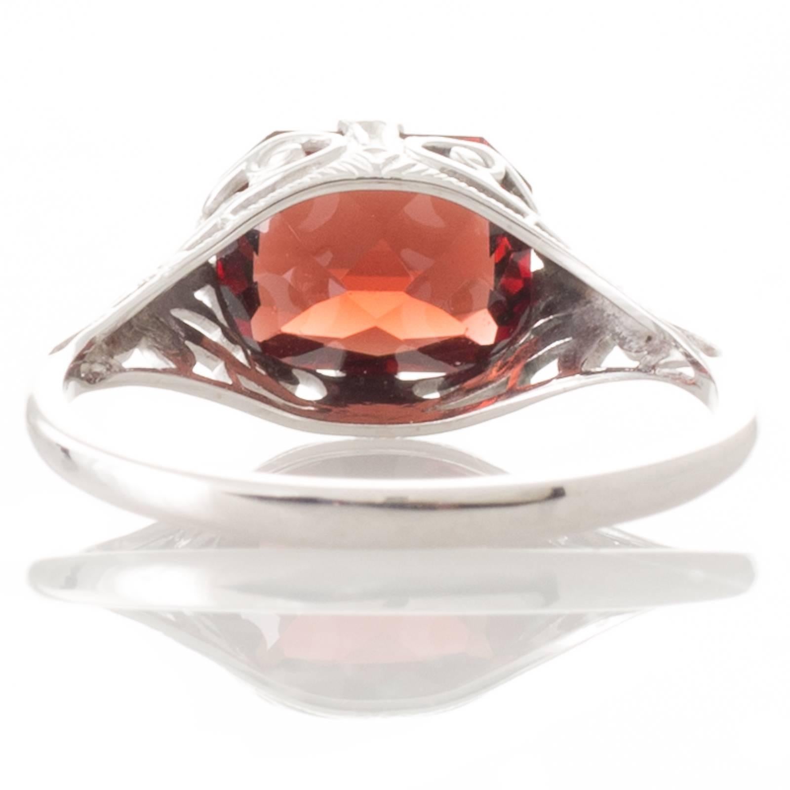 A 14ct white gold antique ring with an emerald cut garnet set horizontally in four double claws above a raised filigree gallery to a fine polished band. 
Total Estimated Garnet Weight: 2.00ct 
Weight: 1.9grams 
