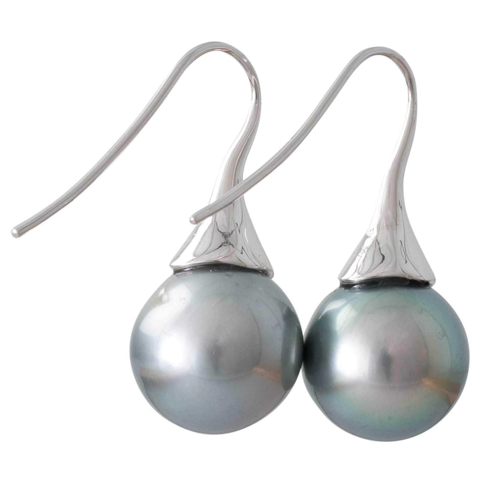 A pair of round green grey Tahitian pearl tulip hook earrings in 18ct white gold with pearls measuring 14.1 - 14.7mm with a good lustre and some natural surface marks.