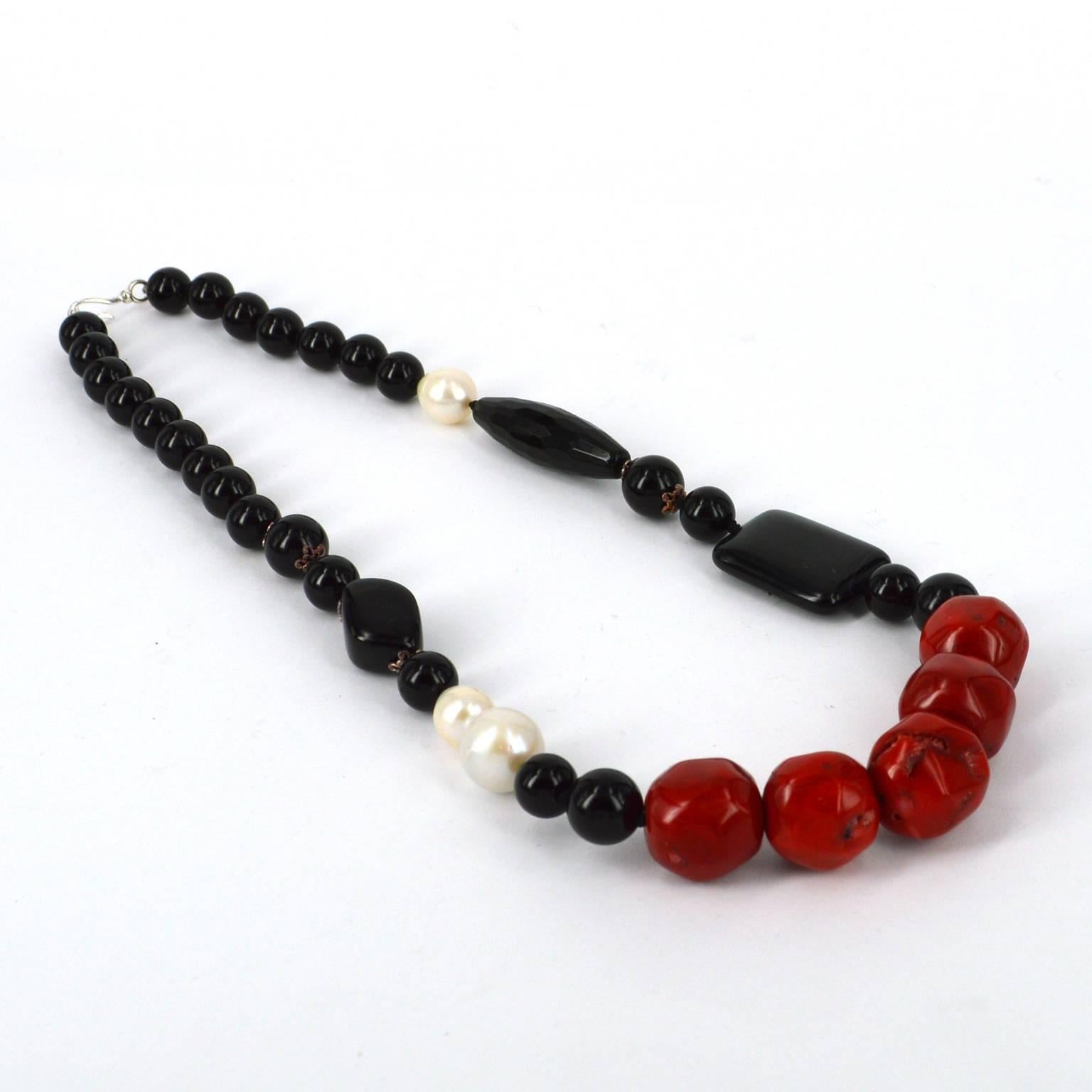 Classic colour combination of Black Red and White with Onyx, Agate, dyed red Bamboo Coral and Freshwater Pearls. Asymmetric pattern make for an interesting yet stylish combination.
Coral nuggets measure at 19mm.
Necklace is hand knotted on black