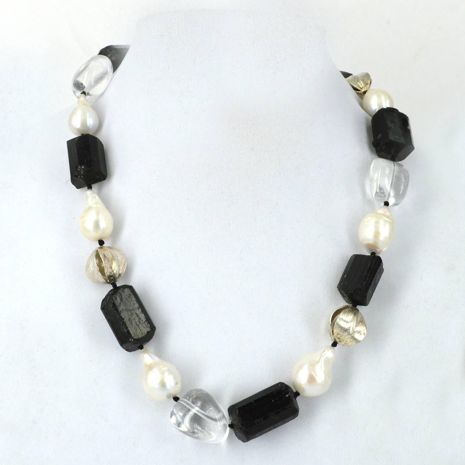 Classic black and white combination. Large Black Tourmaline tubes polished Clear Quartz nuggets Baroque Freshwater Pearls and brushed Sterling Silver fancy beads. Tourmaline tubes measure 26mm x 16mm.
Hand knotted on black thread with 12mm sterling