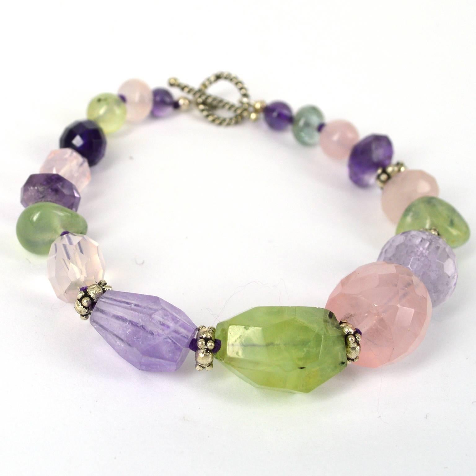 Chunky Bracelet with spaced with Sterling silver beads and knotted on dark purple thread the largest Rose quartz bead is 16x12mm and the finished length is 22.5cm. 
Earrings are Sterling silver 13mm polished Prehnite bead with a 10x7mm faceted Rose